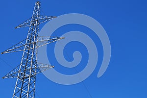 Electricity transmission pylon against blue sky. High voltage electricity pole on sky background