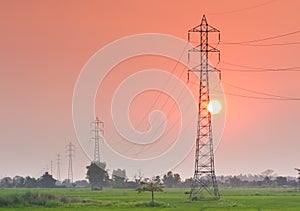 Electricity transmission pylon in the field on sunset