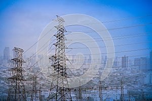 Electricity transmission pylon high voltage pole multiple cityscape on blue sky and clouds