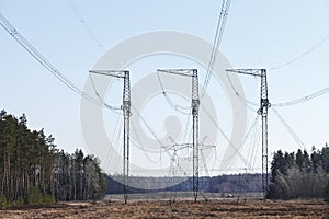 Electricity transmission pylon silhouetted against blue sky