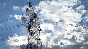 Electricity transmission pylon silhouetted against blue sky at dusk