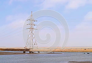 Electricity Transmission Tower with Overhead High-Voltage Power Line Surrounded by Water in Flood -