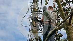 Electricity work, man repairs electric pole wearing all the safety equipment