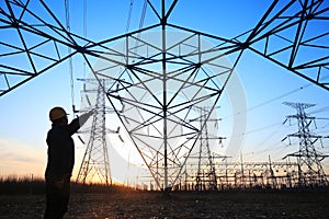 electricity workers and pylon silhouette