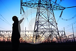 electricity workers and pylon silhouette