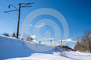 An electrified railway on a trackbed under the snow.