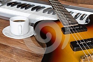 Electro guitar, piano and cap of coffee