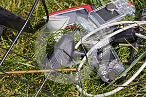 Electro-waste, Old telephones, LEDs, chargers, cables scattered in the grass. The problem of littering and degradation of the