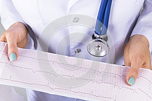 Electrocardiogram, ecg in hand of a female doctor. Medical health care. Clinic cardiology heart rhythm and pulse test closeup.