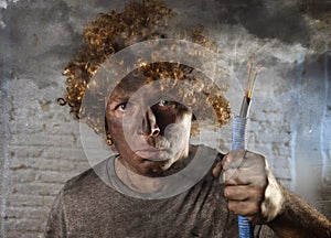 Electrocuted man with cable smoking after domestic accident with dirty burnt face shock electrocuted expression