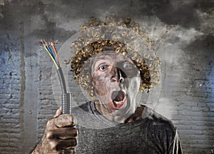 Electrocuted man with cable smoking after domestic accident with dirty burnt face shock electrocuted expression