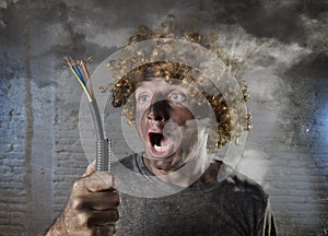 Electrocuted man with cable smoking after domestic accident with dirty burnt face shock electrocuted expression