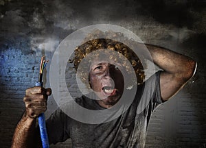 Electrocuted man with cable smoking after domestic accident with dirty burnt face shock electrocuted expression