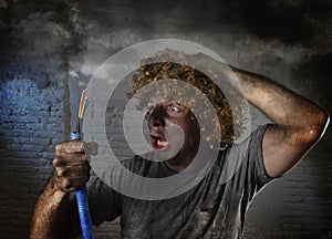 Electrocuted man with cable smoking after domestic accident with dirty burnt face shock electrocuted expression