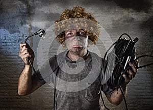 Electrocuted man with cable smoking after domestic accident with dirty burnt face shock electrocuted expression