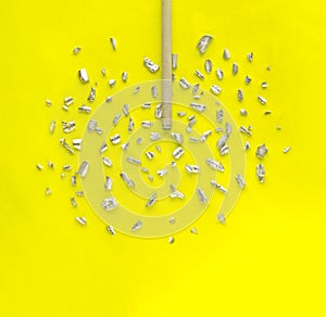 Electrode with crumbs of metal on yellow background. Creative welding concept.