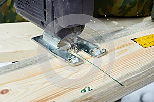 Electrofret saw is sawing wooden board photo