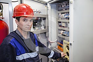 Electromechanic in electrical safety gloves holds power cable, cabling connection of high voltage power electric line in