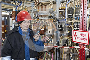 Electromechanic in electrical safety gloves holds power cable, cabling connection of high voltage power electric line in