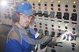 electromechanic in electrical safety gloves holds power cable, cabling connection of high voltage power electric line in