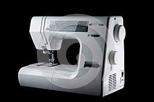 Electromechanical modern white plastic sewing machine on a black background, isolate photo