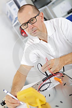 Electromechanical technician inspecting appliance