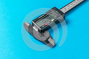Electronic caliper close-up on a blue background