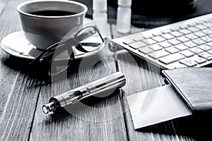 Electronic cigarettes and mens accessories on wooden background