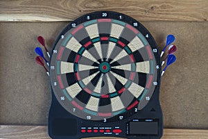 electronic dartboard on wooden background