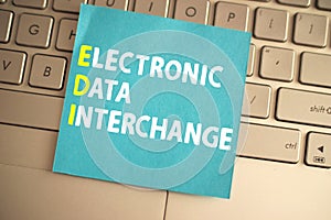 Electronic data interchange, text words typography written on paper against computer keyboard, life and business motivational