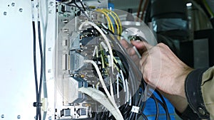 Electronic device assembly or repairing. A male service worker installs part of MRI scanner. Close up of male hands