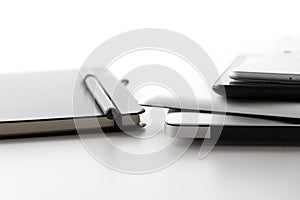 Electronic devices and notebook on white table surface