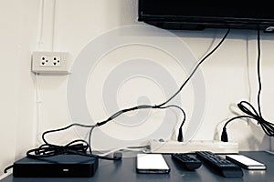 Electronic devices on the table under the TV such as smartphone,tv box,remote all in room