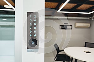 Electronic digital door lock on white office wall close up