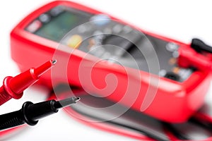 Electronic digital multimeter isolated on white with probes. Digital multimeter with red and black leads. Electronic multimeter is