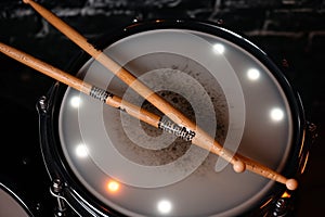 electronic drumsticks resting on a snare drum pad with led indicators