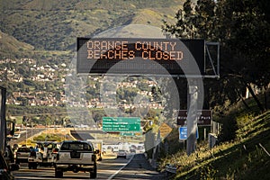 Electronic freeway sign in southern California stating Orange County Beaches Closed