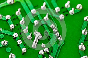 Electronic green printed circuit board with soldered copper tin contacts, close-up, selective focus