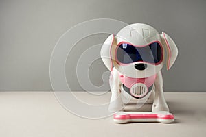 Electronic interactive toy dog puppy on a gray background, high technology concept, pet of the future, electronic home, copy space