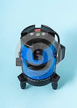 Electronic laser level on light blue background