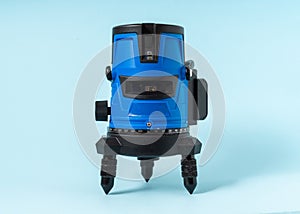 Electronic laser level on light blue background