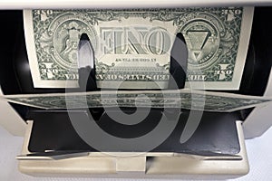 Electronic money counter machine is counting the American one dollar US dollars banknotes