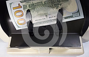 Electronic money counter machine is counting is counting the American hundred-dollar US dollars banknotes