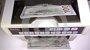 Electronic money counter machine is counting is counting the American hundred-dollar US dollars banknotes