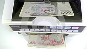 Electronic money counter machine is counting the Uzbekistan sum