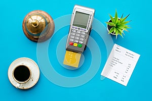 Electronic payments. Pay the bill by card concept. Bank card inserted in payment terminal near bill, service bell