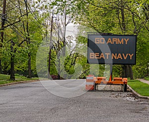 Electronic road sign on a suburban street that says Go Army Beat Navy.