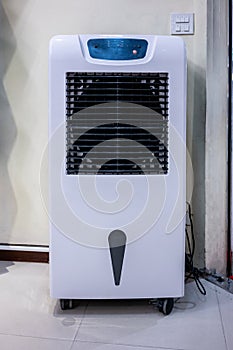Electronic room tower fan and humidifier on white wall