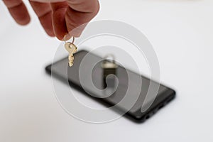 Electronic security and data protection concept. Mobile phone and key lock