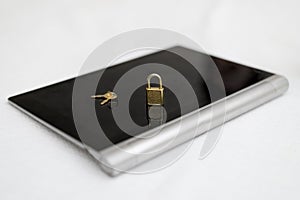 Electronic security and data protection concept. Tablet computer and lock with keys